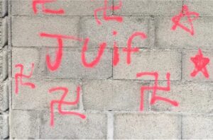 The author(s) used a fluorescent pink spray paint that was on the site to write their anti-Semitic tags. - Saint-Alban-Auriolles town hall