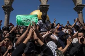 Palestinians chant slogans and wave Hamas flags during a protest against Israel at the Al-Aqsa Mosque compound.(AP: Mahmoud Illean)