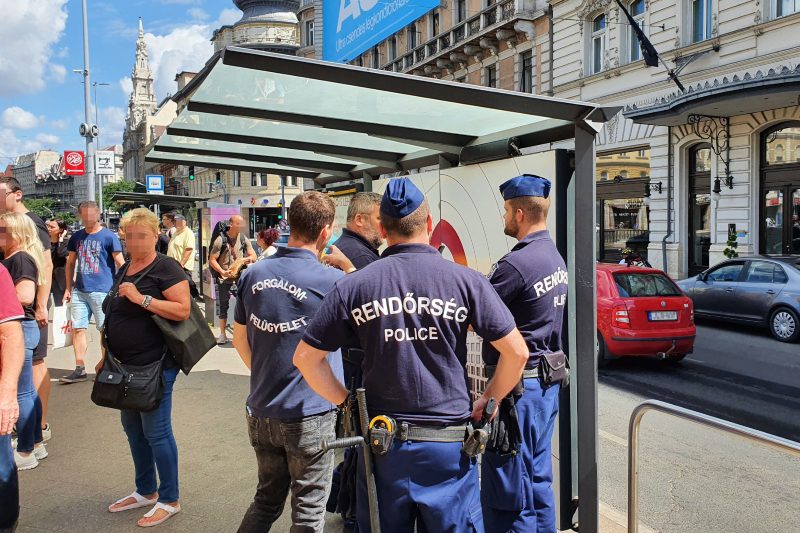 Police officers examine the billboard with a loudspeaker - Photo: Balázs Bozzay / Telex