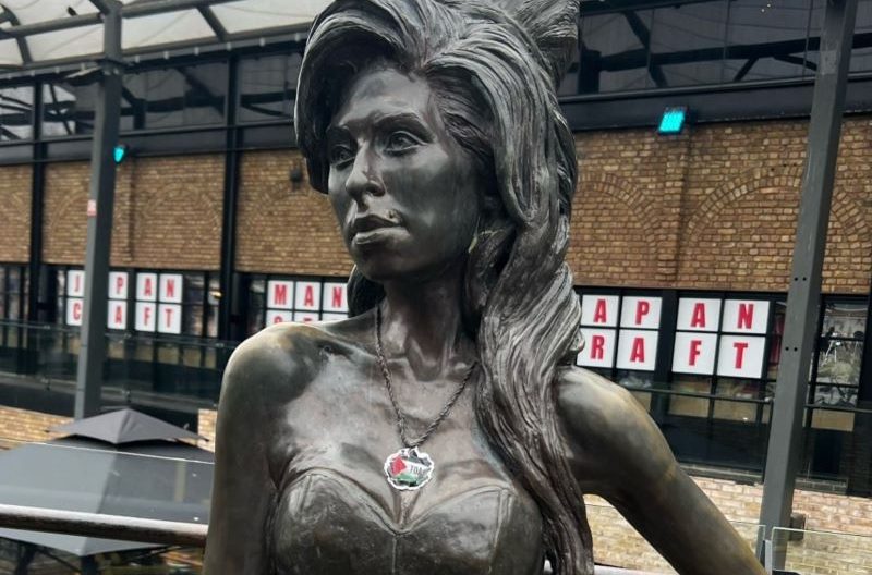 A Star of David necklace on a statue of Amy Winehouse at Camden Market is covered with a sticker of a Palestinian flag.